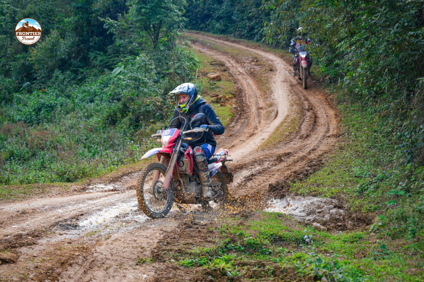 Rural Vietnamese road with loose gravel illustrating unpredictable riding conditions